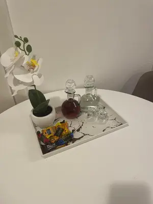 a tray on a table with two glass jars and a plant at Roza in Ruma