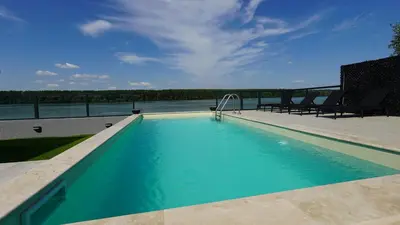 a swimming pool with a view of the water at River House Sunrise in Ritopek