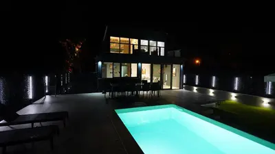 a house with a swimming pool at night at River House Sunrise in Ritopek