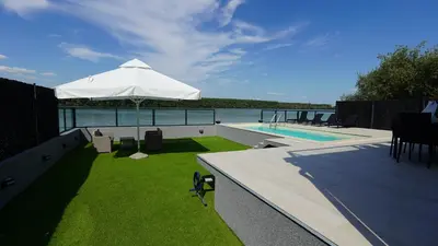 a patio with an umbrella next to a swimming pool at River House Sunrise in Ritopek