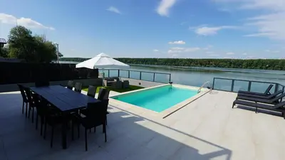 a patio with a table and a swimming pool at River House Sunrise in Ritopek