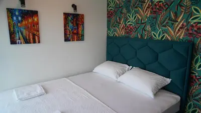 a bed in a room with two paintings on the wall at River House Sunrise in Ritopek