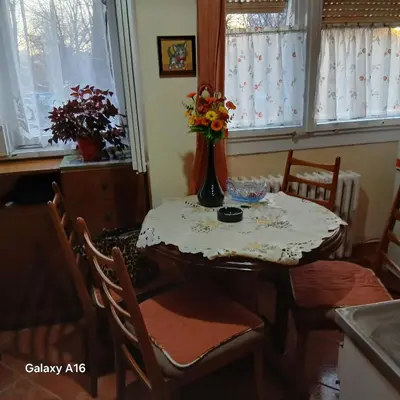 a dining room table with a vase of flowers on it at Rajka in Belgrade