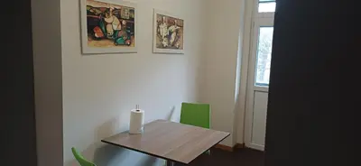 a room with a table and two green chairs at LP apartment in Belgrade