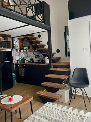 a living room with a spiral staircase and a table at City Loft in Belgrade