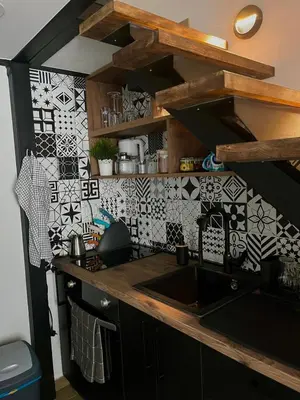 a kitchen with a sink and black and white tiles at City Loft in Belgrade