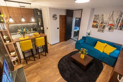 a living room with a blue couch and a kitchen at Moon Apartment Belgrade in Belgrade