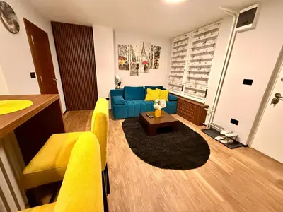 a living room with a blue couch and a table at Moon Apartment Belgrade in Belgrade