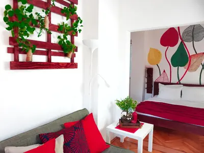 a bedroom with a bed with red and green plants at Villa K Apartments in Belgrade