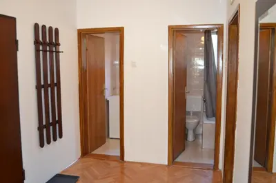a bathroom with a toilet and a glass door at Villa K Apartments in Belgrade