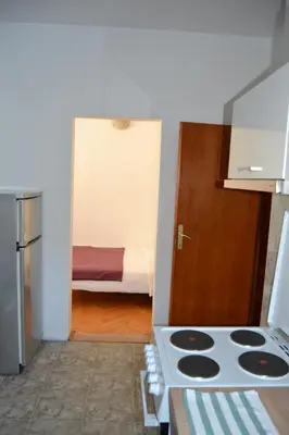a kitchen with a stove and a room with a bed at Villa K Apartments in Belgrade