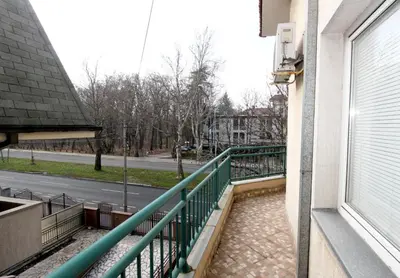 a balcony with a green railing and a street at Villa K Apartments in Belgrade