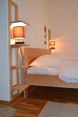 a bedroom with a wooden bed with two lamps at Villa K Apartments in Belgrade
