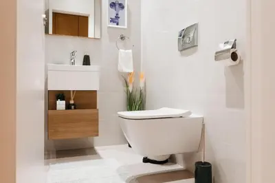 a bathroom with a white toilet and a sink at WF Timeless Residence with Terrace & Foosball in Belgrade