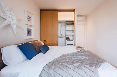 a bedroom with a large white bed with blue pillows at WF Timeless Residence with Terrace & Foosball in Belgrade