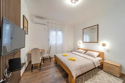 a bedroom with a bed and a desk and a television at Nele Belgrade Apartment in Belgrade