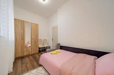 a bedroom with a pink bed and a mirror at Nele Belgrade Apartment in Belgrade