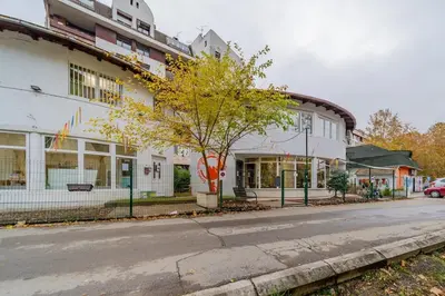 a building with a tree in front of a street at Nele Belgrade Apartment in Belgrade