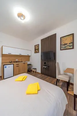 a bedroom with a large white bed with yellow towels on it at Nele Belgrade Apartment in Belgrade