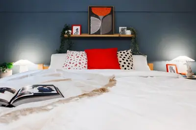 a bedroom with a white bed with a book on it at Foosball Frontyard Retreat Old Town in Belgrade