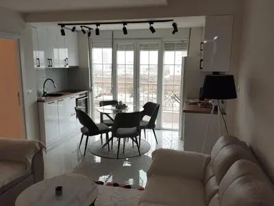 a living room with a couch and a table and chairs at VauDa White apartman in Belgrade