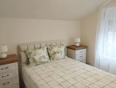 a bedroom with a bed and two dressers and a window at VauDa White apartman in Belgrade