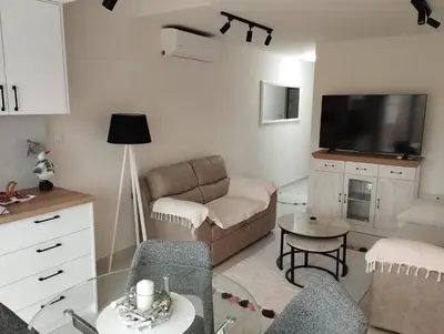 a living room with a couch and a tv at VauDa White apartman in Belgrade