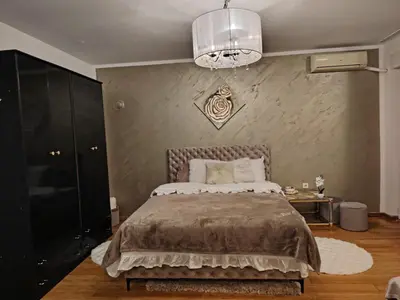 a bedroom with a large bed and a chandelier at Roza in Ruma