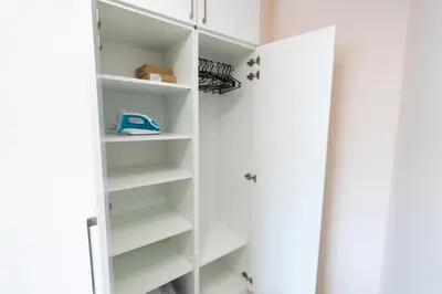 a white closet with white doors and shelves at Old Town Lounge Belgrade in Belgrade