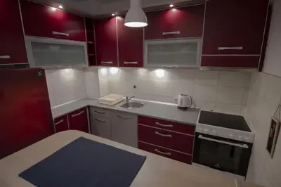 a small kitchen with red cabinets and a sink at Slavija Square Apartments in Belgrade