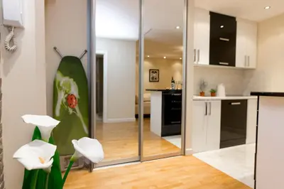a modern kitchen with a large green leaf painting on the wall at Slavija Square Apartments in Belgrade