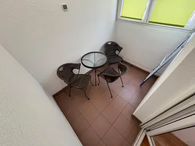 a table and chairs in a room with a window at Apartment Zumbul 85 in Belgrade