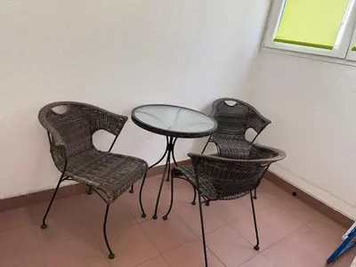 three chairs and a glass table in a room at Apartment Zumbul 85 in Belgrade