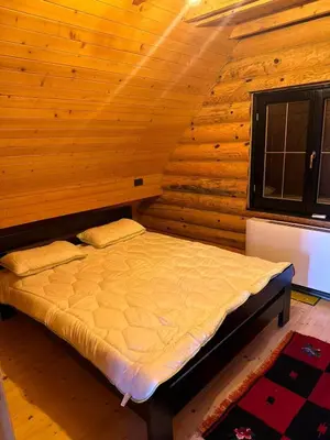 a bedroom with a bed in a wooden room at Lux Wood in Boljevci