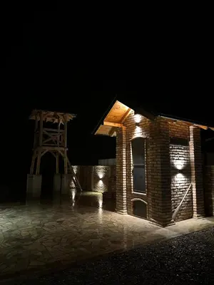 a brick building with lights on it at night at Lux Wood in Boljevci