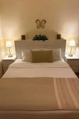 a bedroom with a large white bed with two lamps at Studio Slaviya in Belgrade