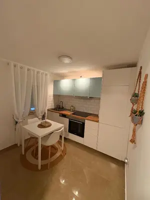 a kitchen with a white table and a white refrigerator at Studio Slaviya in Belgrade