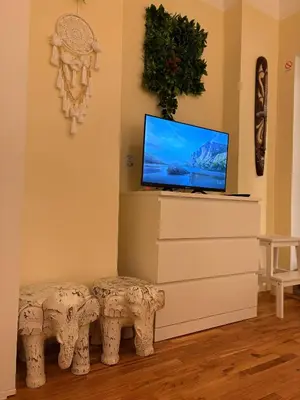 a living room with a tv and two stools at Studio Slaviya in Belgrade