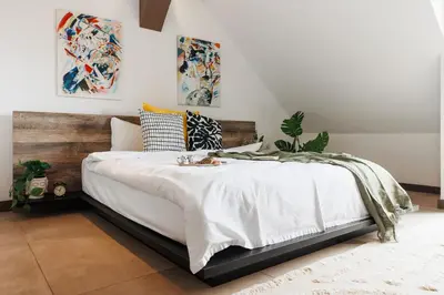 a bedroom with a bed with white blankets and pillows at Penthouse View with Sauna & Jacuzzi Old Town in Belgrade