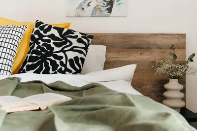 a bedroom with a bed with a book and pillows at Penthouse View with Sauna & Jacuzzi Old Town in Belgrade