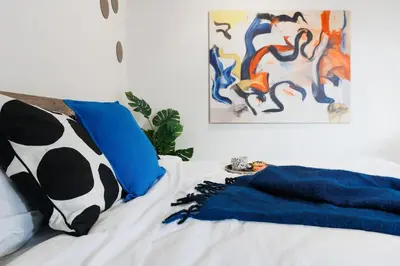 a bedroom with a bed with a blanket and a painting at Penthouse View with Sauna & Jacuzzi Old Town in Belgrade