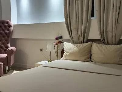 a bedroom with a large white bed with a chair at Panajota Apartment in city centre in Belgrade