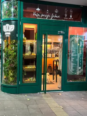 a green store front with glass doors on a street at Panajota Apartment in city centre in Belgrade