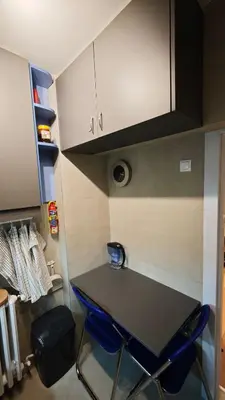 a kitchen with a table and two blue chairs at House of Mirrors in Belgrade