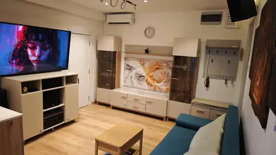 a living room with a tv and a blue couch at House of Mirrors in Belgrade