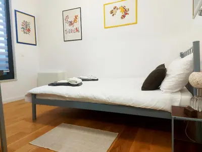 a bed in a room with a white wall at Danube Riverfront 8 in Belgrade
