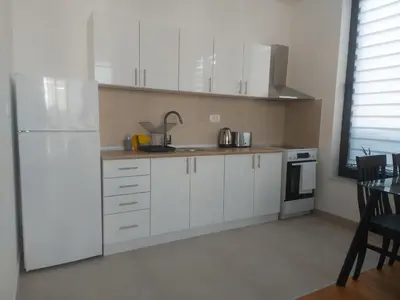 a kitchen with white cabinets and a white refrigerator at Danube View 11 in Zemun