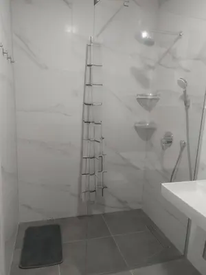 a white bathroom with a shower and a sink at Danube View 11 in Zemun