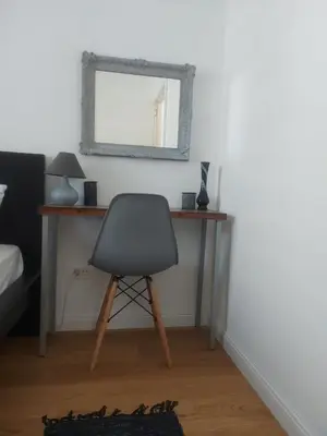 a desk with a chair and a mirror on a wall at Danube View 11 in Zemun