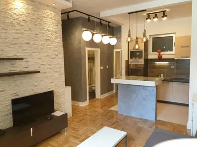 a living room with a large kitchen with a tv at Apartment Theatre in Belgrade